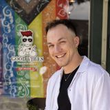 Adam by the shop window, rainbow flag in the background